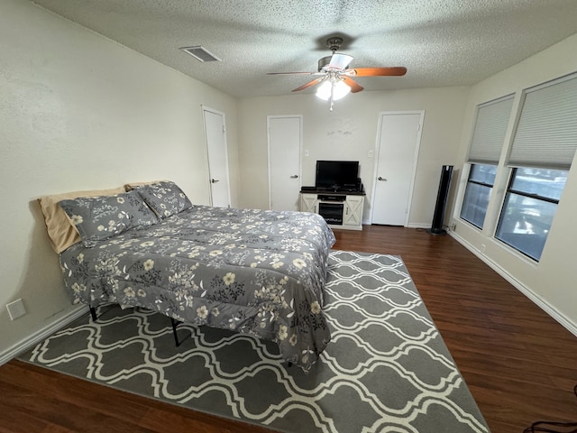 bedroom featuring ceiling fan, dark wood-type flooring, and a textured ceiling