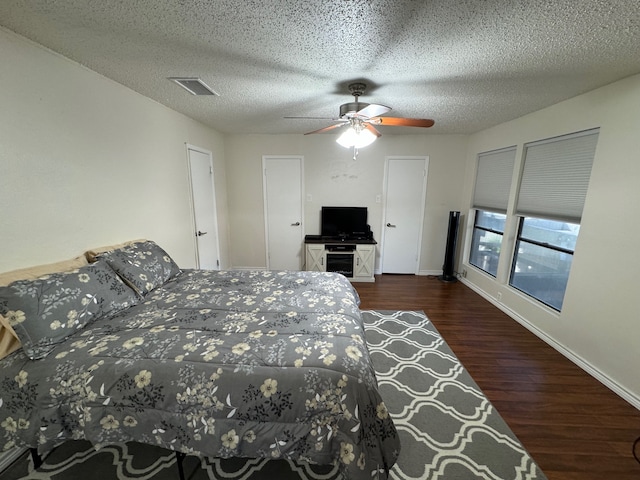 bedroom featuring a textured ceiling, dark hardwood / wood-style floors, and ceiling fan