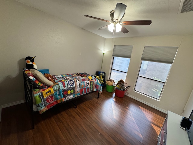 bedroom with dark hardwood / wood-style floors and ceiling fan