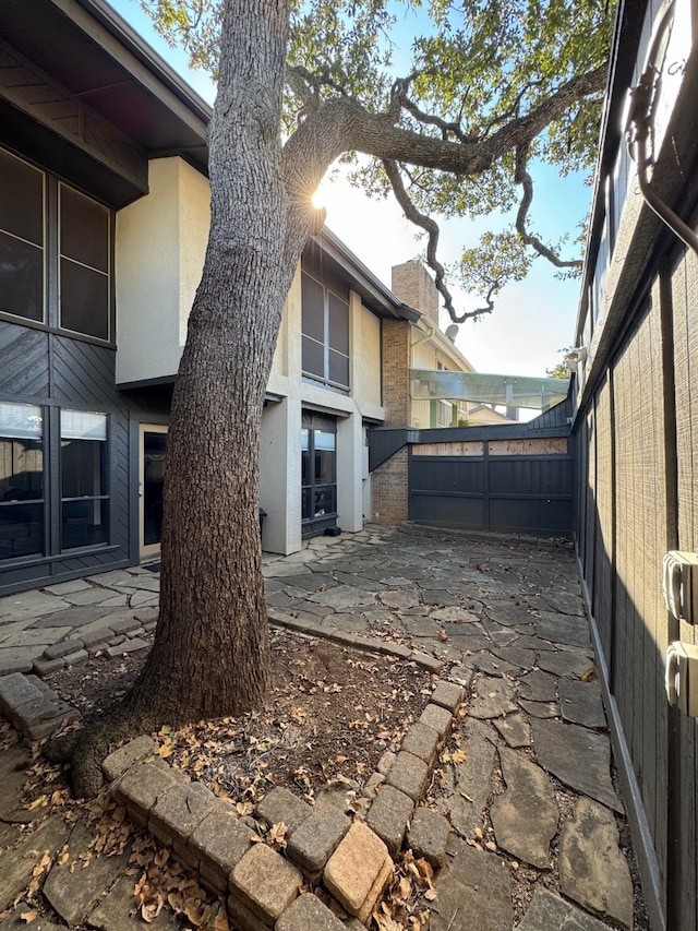 311 Oak Shadow Cir, Bedford, TX 76021 - view of property exterior featuring a patio, stucco siding, and brick siding