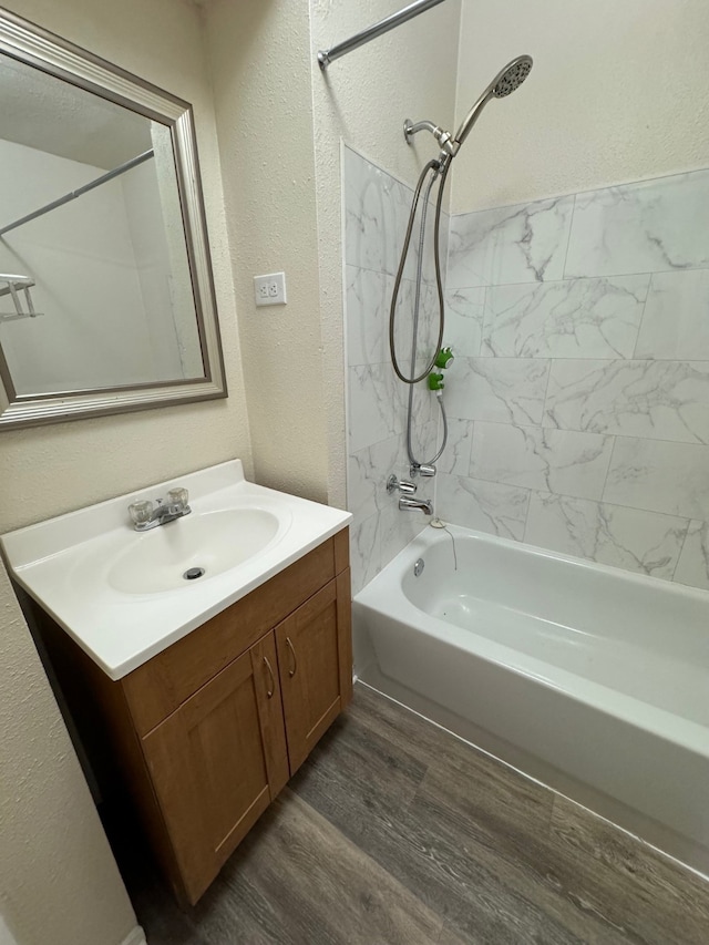 bathroom featuring vanity, hardwood / wood-style flooring, and tiled shower / bath