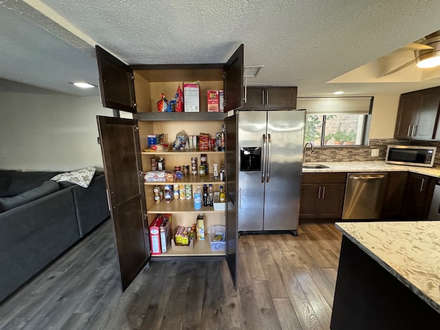 311 Oak Shadow Cir, Bedford, TX 76021 - kitchen with stainless steel appliances, dark wood-type flooring, a sink, a textured ceiling, and dark brown cabinetry