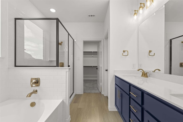 bathroom featuring hardwood / wood-style flooring, shower with separate bathtub, and vanity