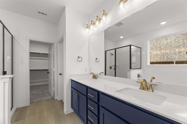 bathroom with vanity, hardwood / wood-style floors, and a shower with door