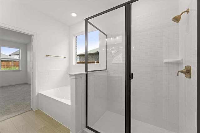 bathroom featuring shower with separate bathtub