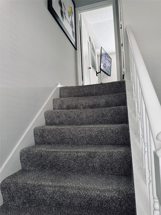 stairway with a textured ceiling