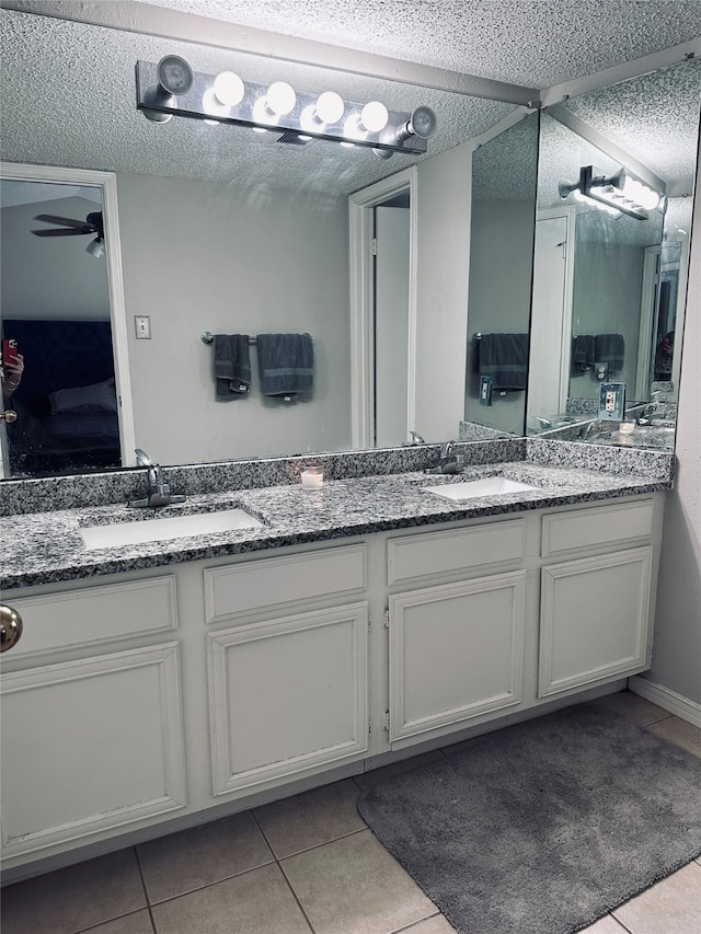 bathroom featuring tile patterned flooring, ceiling fan, vanity, and a textured ceiling