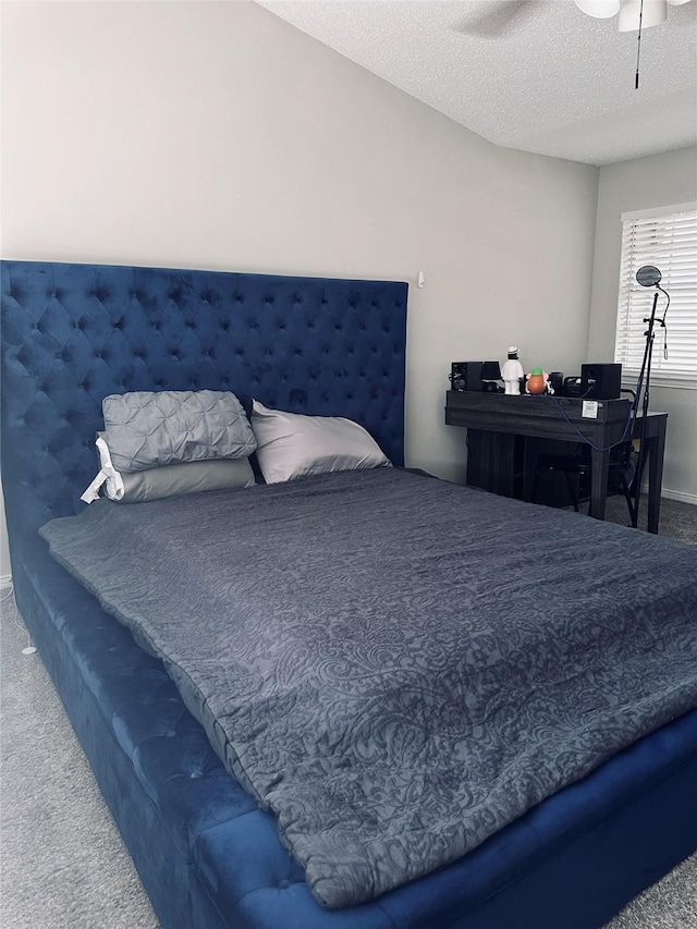 carpeted bedroom featuring ceiling fan and a textured ceiling