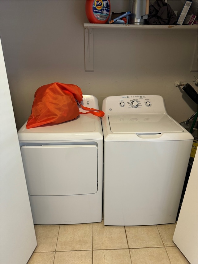 clothes washing area featuring separate washer and dryer and light tile patterned floors