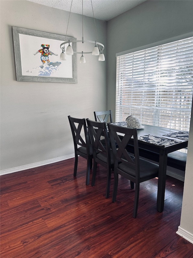 dining room with a textured ceiling and dark wood-type flooring