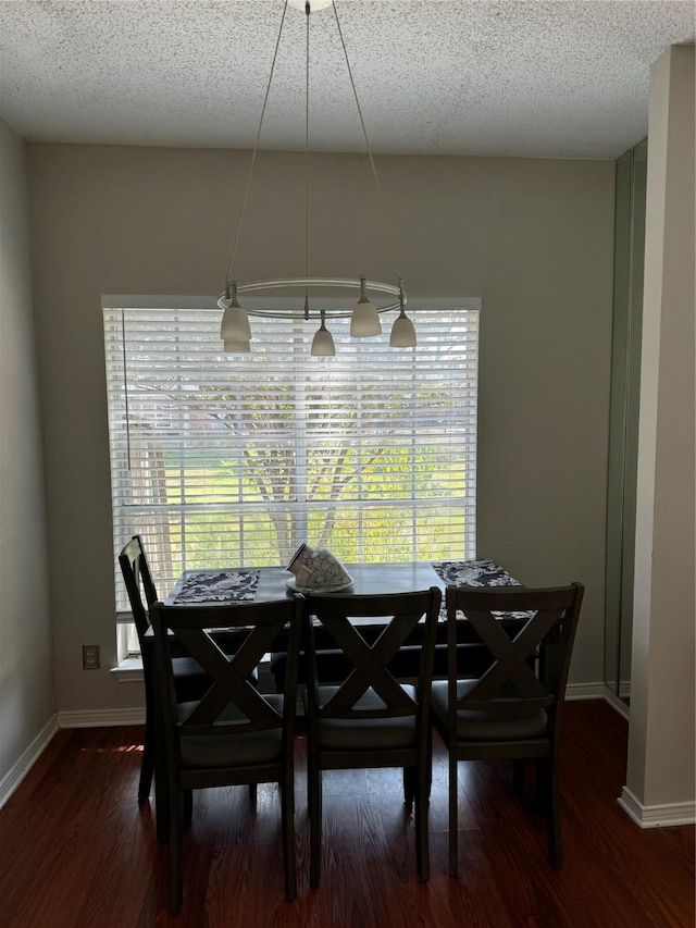 dining space with dark hardwood / wood-style flooring and a textured ceiling