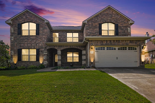 view of front of house featuring a garage and a yard