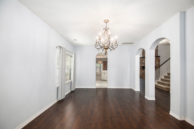 unfurnished dining area with a notable chandelier and dark wood-type flooring