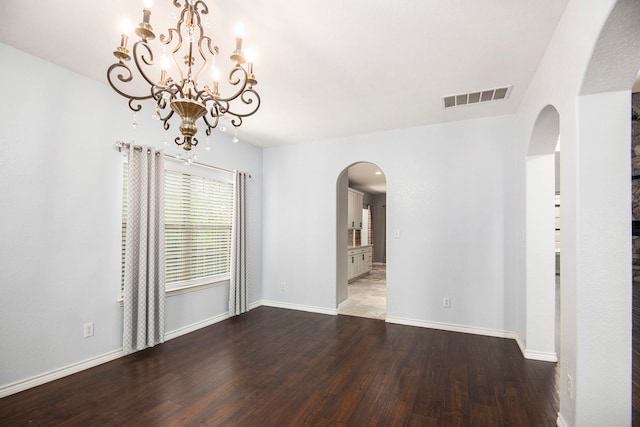 empty room with an inviting chandelier and hardwood / wood-style flooring