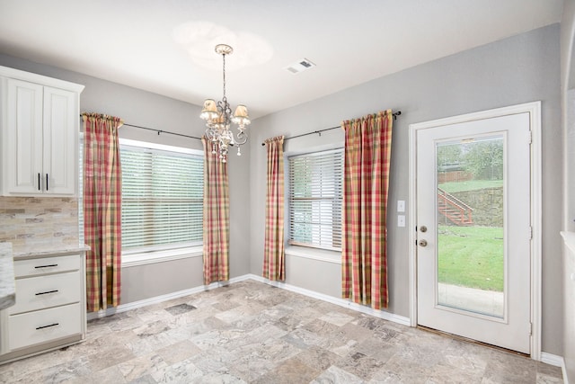 unfurnished dining area featuring plenty of natural light and a chandelier