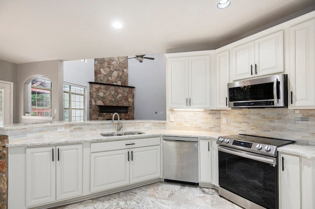 kitchen featuring sink, appliances with stainless steel finishes, kitchen peninsula, and white cabinetry