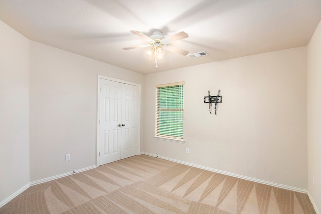 carpeted empty room with ceiling fan