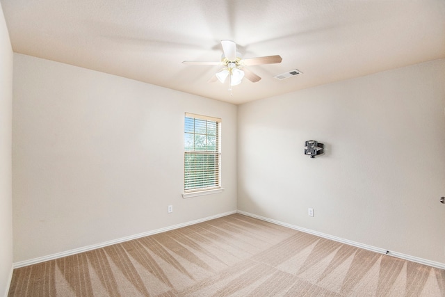 carpeted spare room featuring ceiling fan