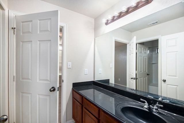 bathroom with walk in shower and vanity