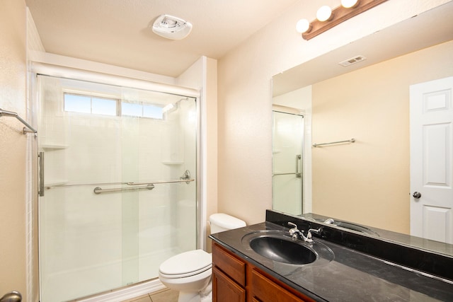 bathroom with vanity, toilet, tile patterned floors, and a shower with door