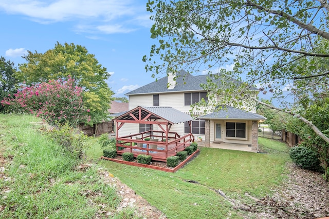 back of property featuring a wooden deck, a yard, and a patio area