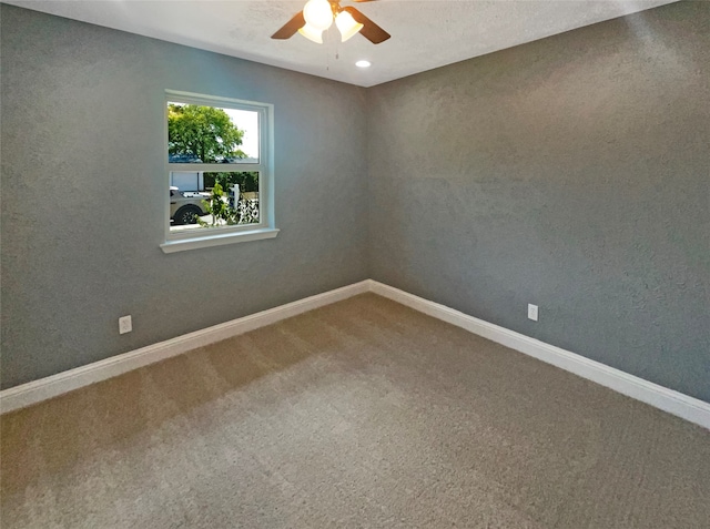 carpeted spare room with ceiling fan and a textured ceiling