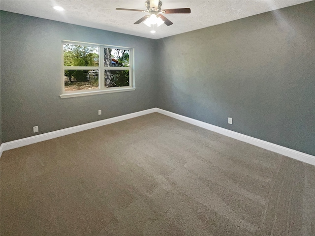 unfurnished room with carpet, ceiling fan, and a textured ceiling