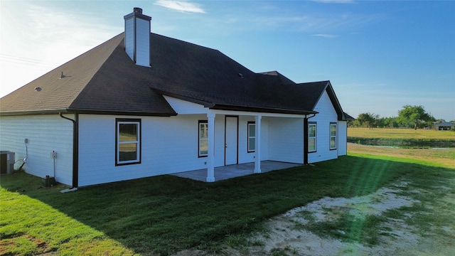 back of house with a lawn and a patio area