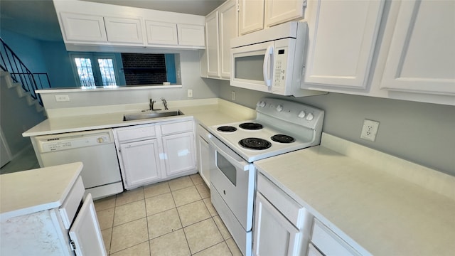 kitchen with light tile patterned floors, sink, white appliances, and white cabinetry