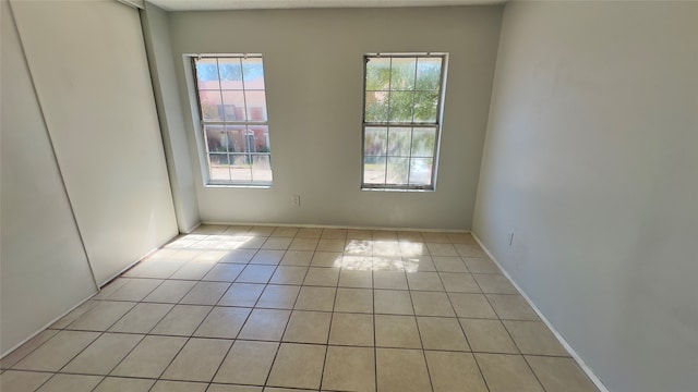 tiled spare room with a healthy amount of sunlight