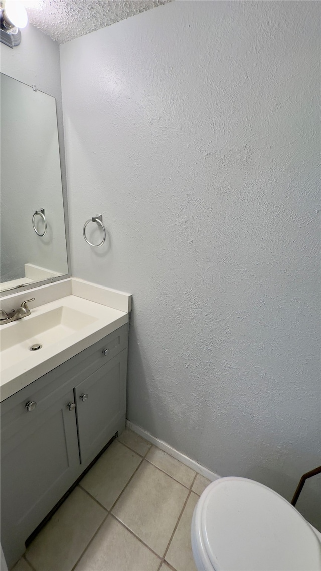 bathroom featuring tile patterned flooring, vanity, and toilet