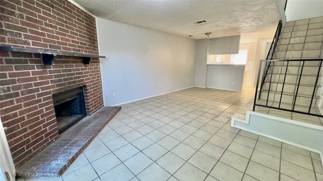 unfurnished living room featuring a textured ceiling, a fireplace, and light tile patterned floors