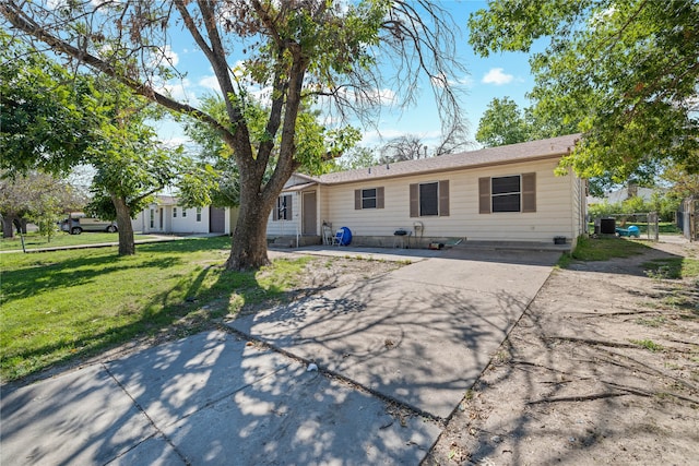 ranch-style home featuring cooling unit, a front lawn, and a patio area