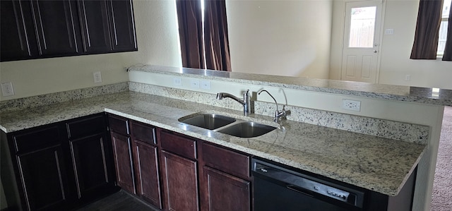 kitchen with black dishwasher, sink, light stone counters, and kitchen peninsula