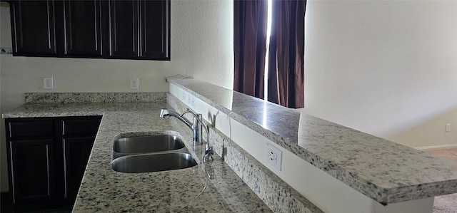 kitchen featuring light stone countertops and sink