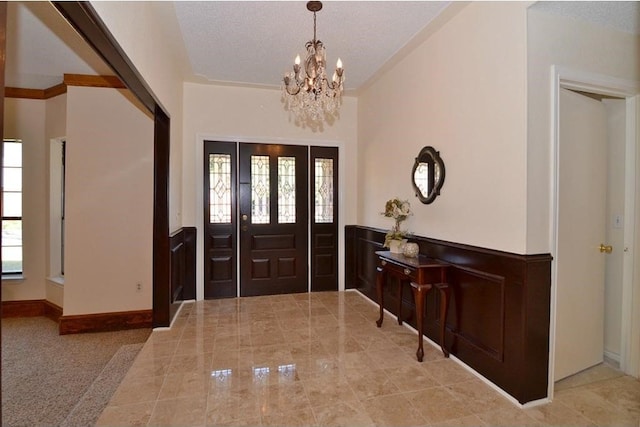 entryway with a notable chandelier and a textured ceiling