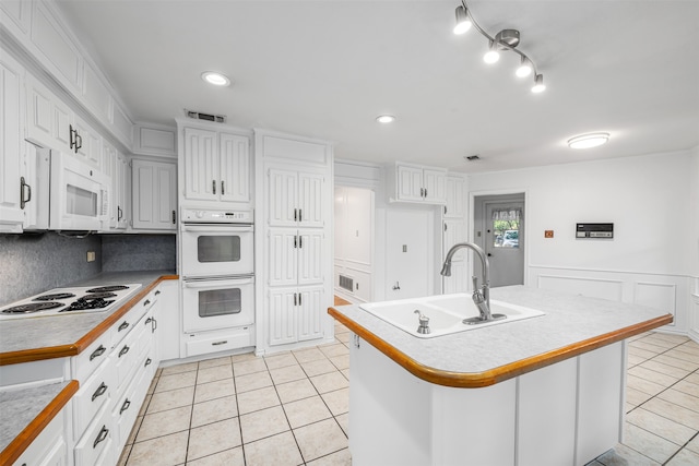 kitchen featuring white cabinetry, a kitchen island with sink, and sink