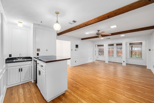 kitchen featuring white cabinetry, beamed ceiling, light hardwood / wood-style flooring, ceiling fan, and sink