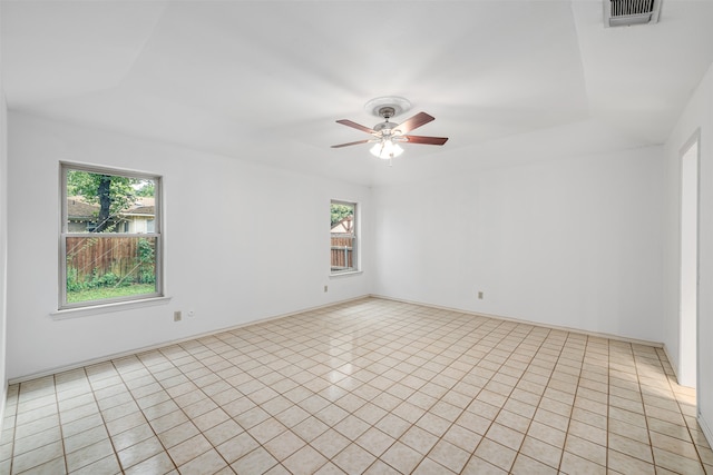 tiled empty room with ceiling fan and a healthy amount of sunlight