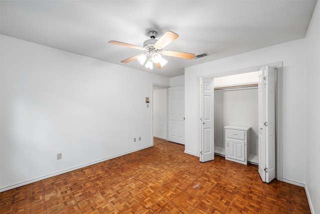 unfurnished bedroom featuring ceiling fan and dark parquet flooring