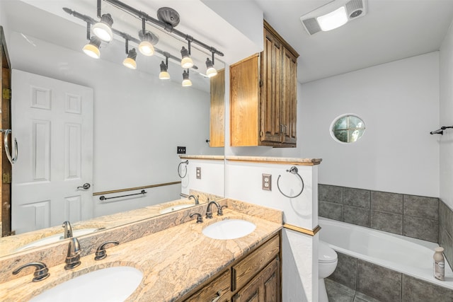 bathroom featuring tile patterned floors, tiled bath, vanity, and toilet