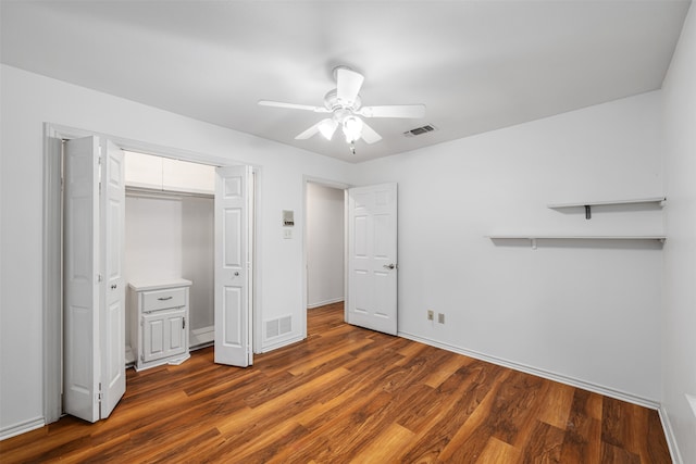 unfurnished bedroom featuring ceiling fan, a closet, and dark hardwood / wood-style flooring