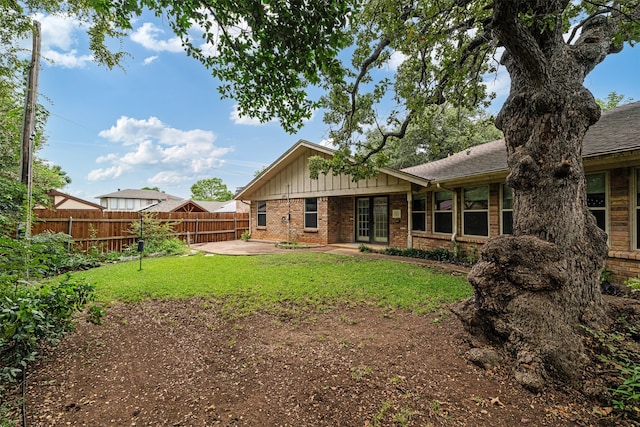 back of property featuring a yard and a patio area