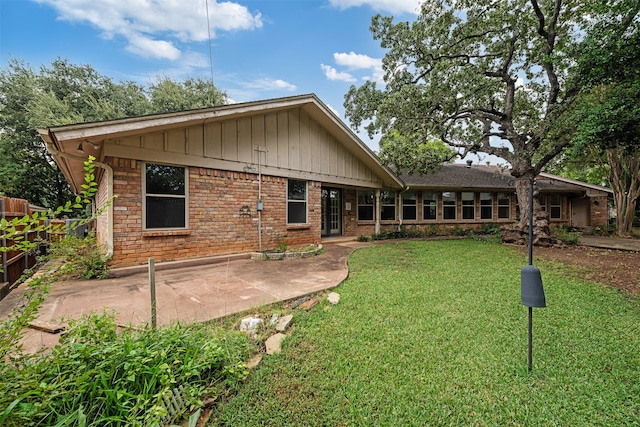 back of house featuring a yard and a patio area