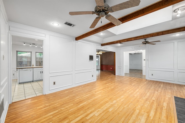 unfurnished living room featuring ceiling fan, beamed ceiling, and light hardwood / wood-style flooring