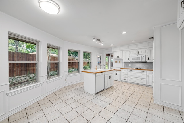 kitchen with sink, white cabinets, a kitchen island, white appliances, and wooden counters