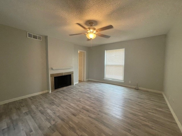 unfurnished living room featuring a textured ceiling, wood-type flooring, and ceiling fan