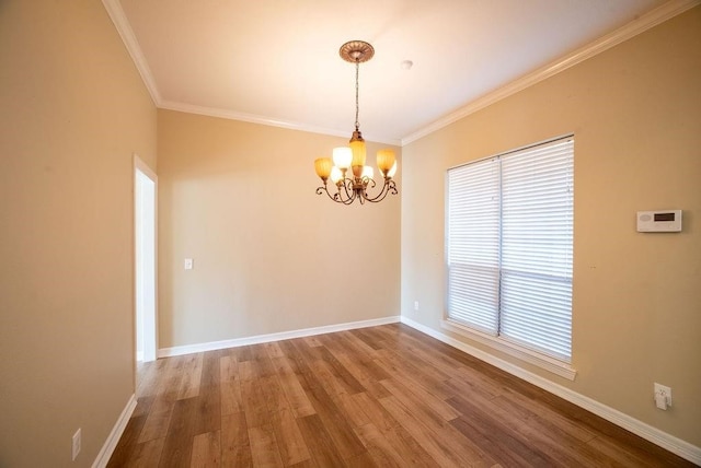 unfurnished room with ornamental molding, a notable chandelier, plenty of natural light, and hardwood / wood-style floors