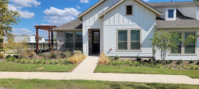 view of front facade with a front yard and a pergola