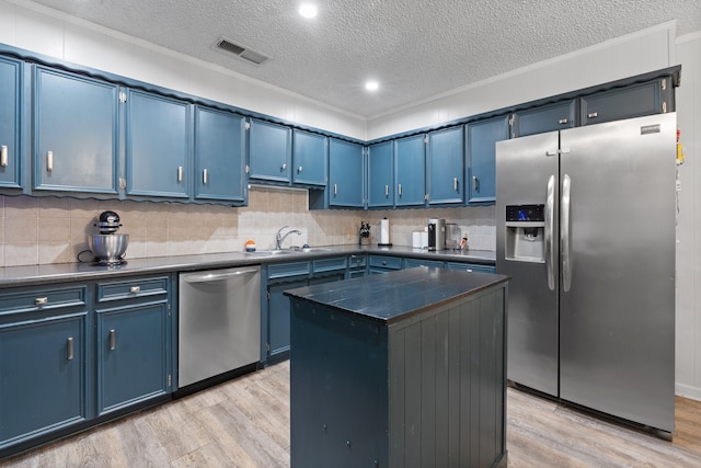 kitchen with a textured ceiling, a center island, light hardwood / wood-style flooring, appliances with stainless steel finishes, and blue cabinets